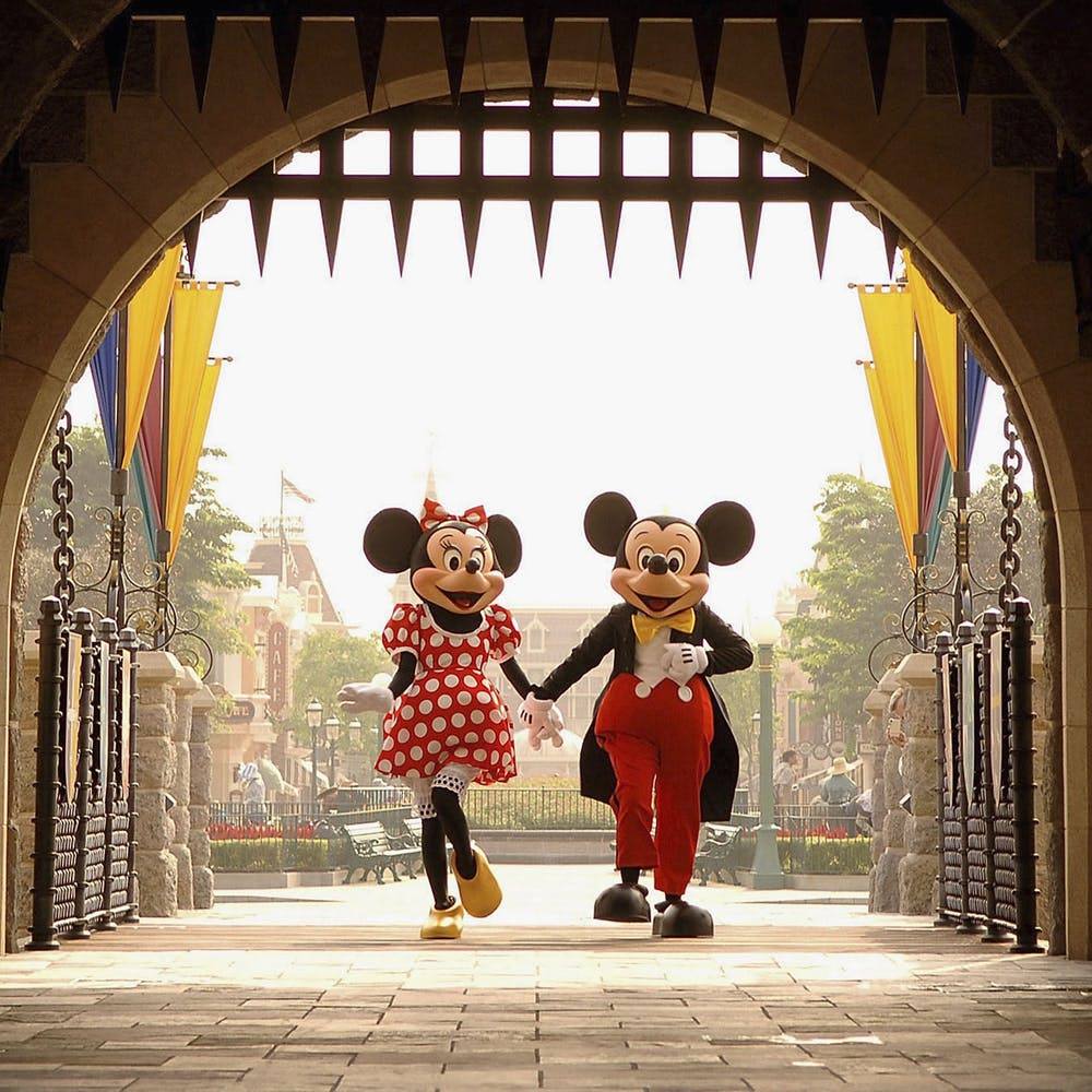 Mickey and Minnie walking through Cinderella castle.